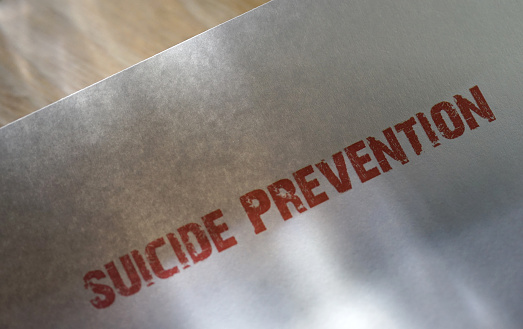 "Suicide Prevention" in red on a white piece of paper.