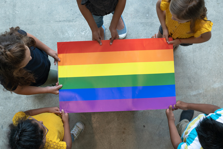 Youth holding a rainbow pride poster