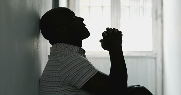 Young male sitting in a hallway, feeling depressed.